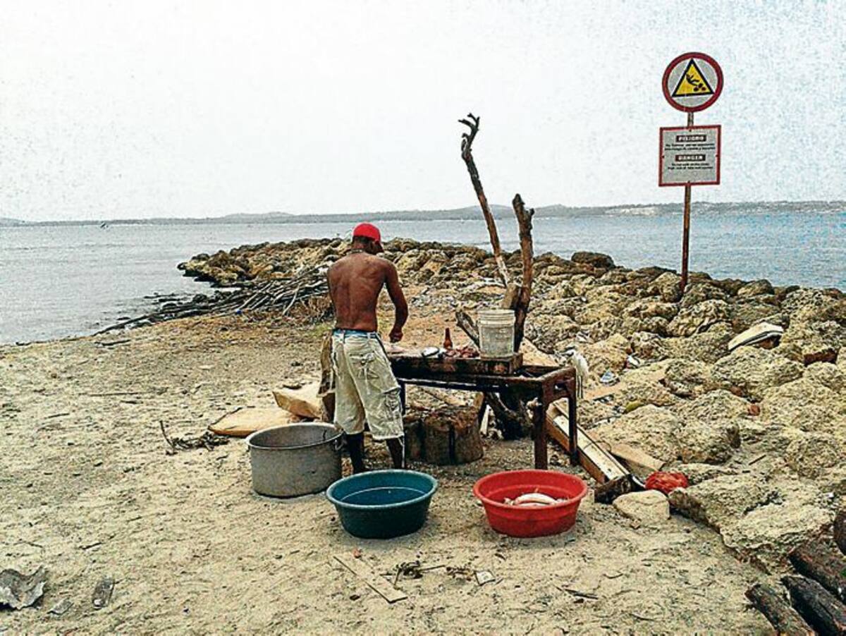 Sin miramiento alguno cocinan a la orilla de la playa.
