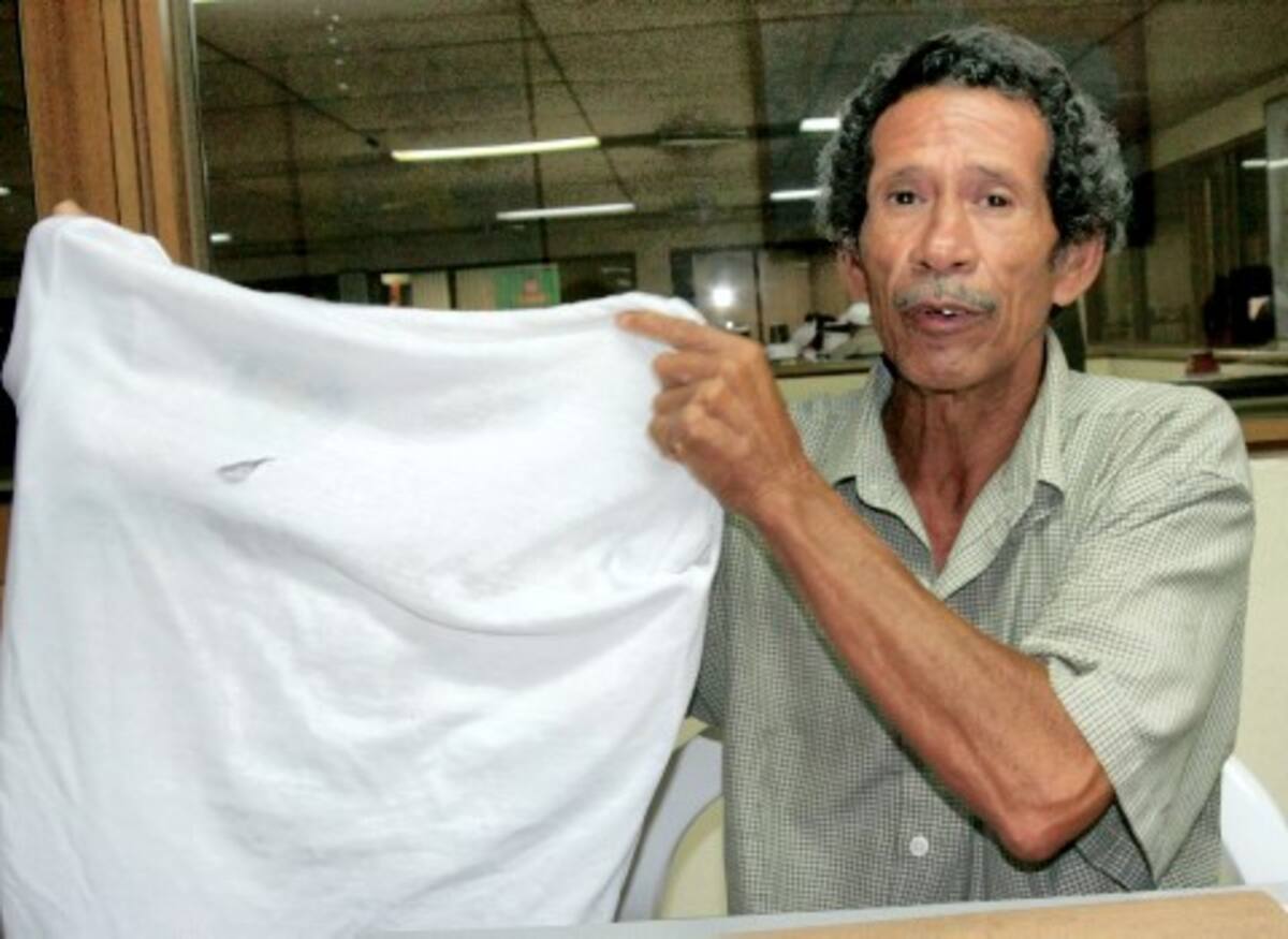 Juan Garcés muestra la camiseta que su hijo llevaba puesta el día de los hechos. Él dice que pocas personas le prestaron ayuda, pese a la herida que le causaron frente al colegio.