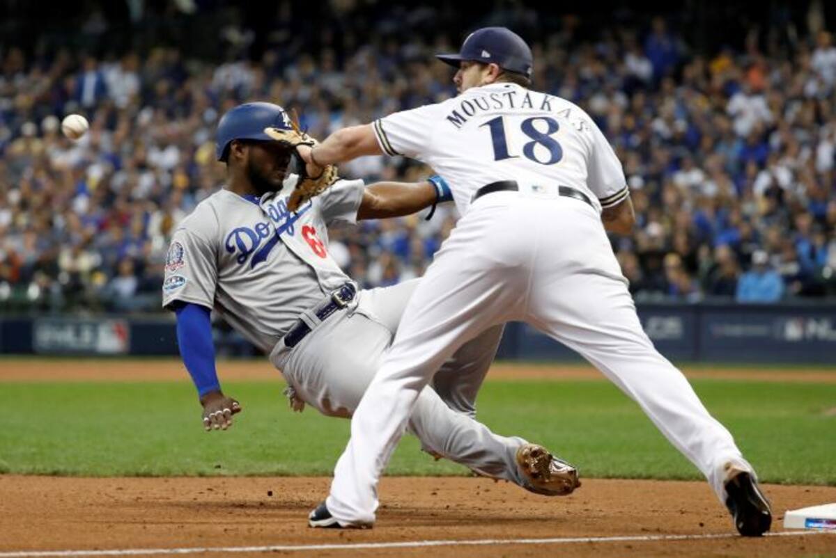 Yasiel Puig (66) de los Dodgers de Los Angeles se desliza con seguridad al tercer lugar contra Mike Moustakas (18) de los cerveceros de Milwaukee. AP Jeff Roberson