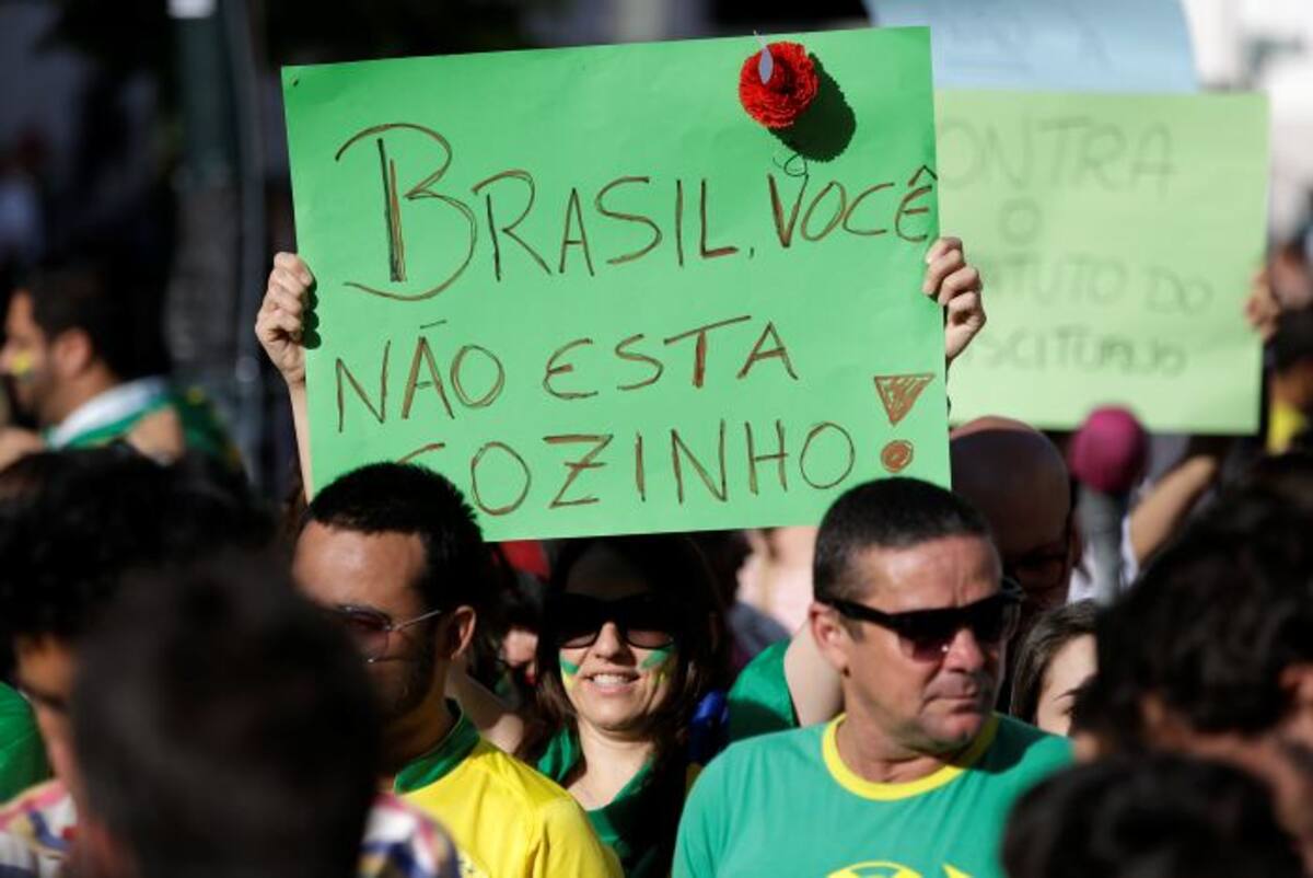 Una manifestante sostiene un cartel con el mensaje en portugués "Brasil, usted no está solo", durante una de las protestas que se realizan en ese país. AP