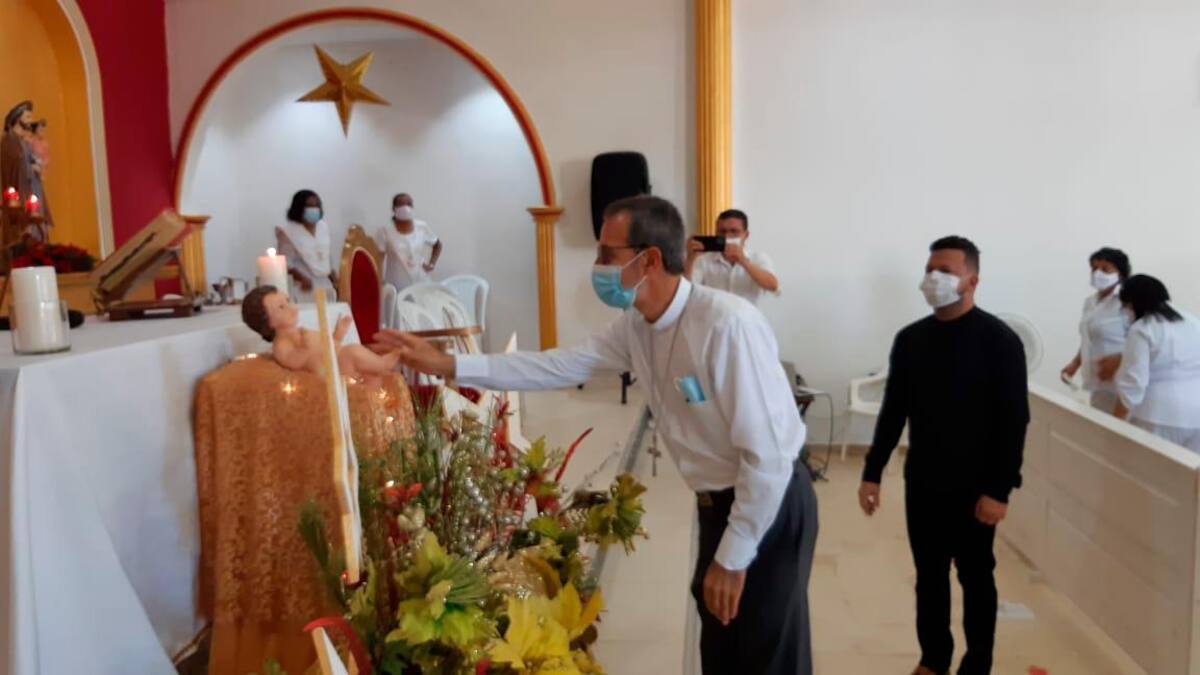 Monseñor bendice el altar con el nacimiento del Niño Jesús.