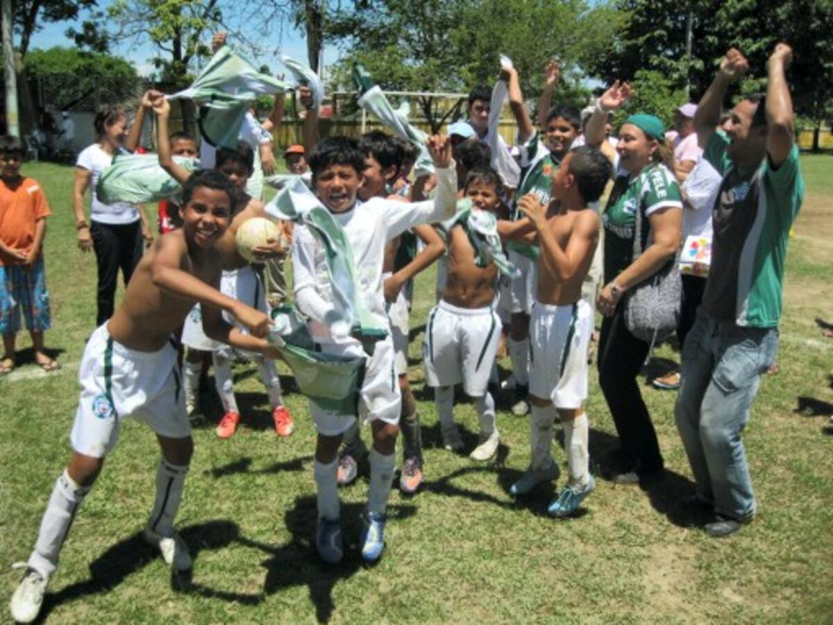 Los niños de la escuela Rey Pelé, padres de familia y aficionados festejan el título del Festival de Fútbol.