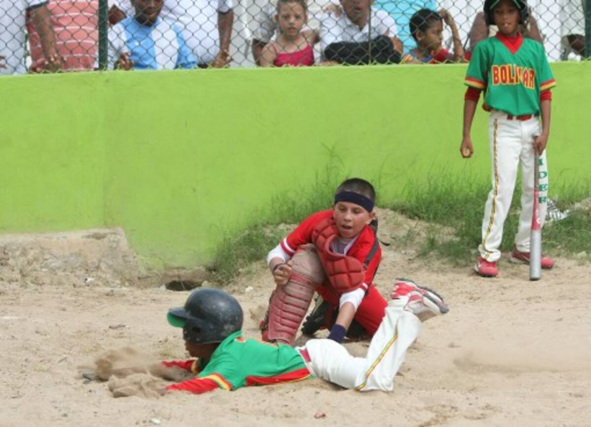 Dayan Frías, de Bolívar, hace una espectacular zambullida en el plato para anotar una carrera, mientras que el receptor de Valle, Kevin Gómez, no logra ponerlo en out, en una acción del juego de ayer en el estadio Claudio Muñoz de Martínez Martelo. Aroldo Mestre-El Universal