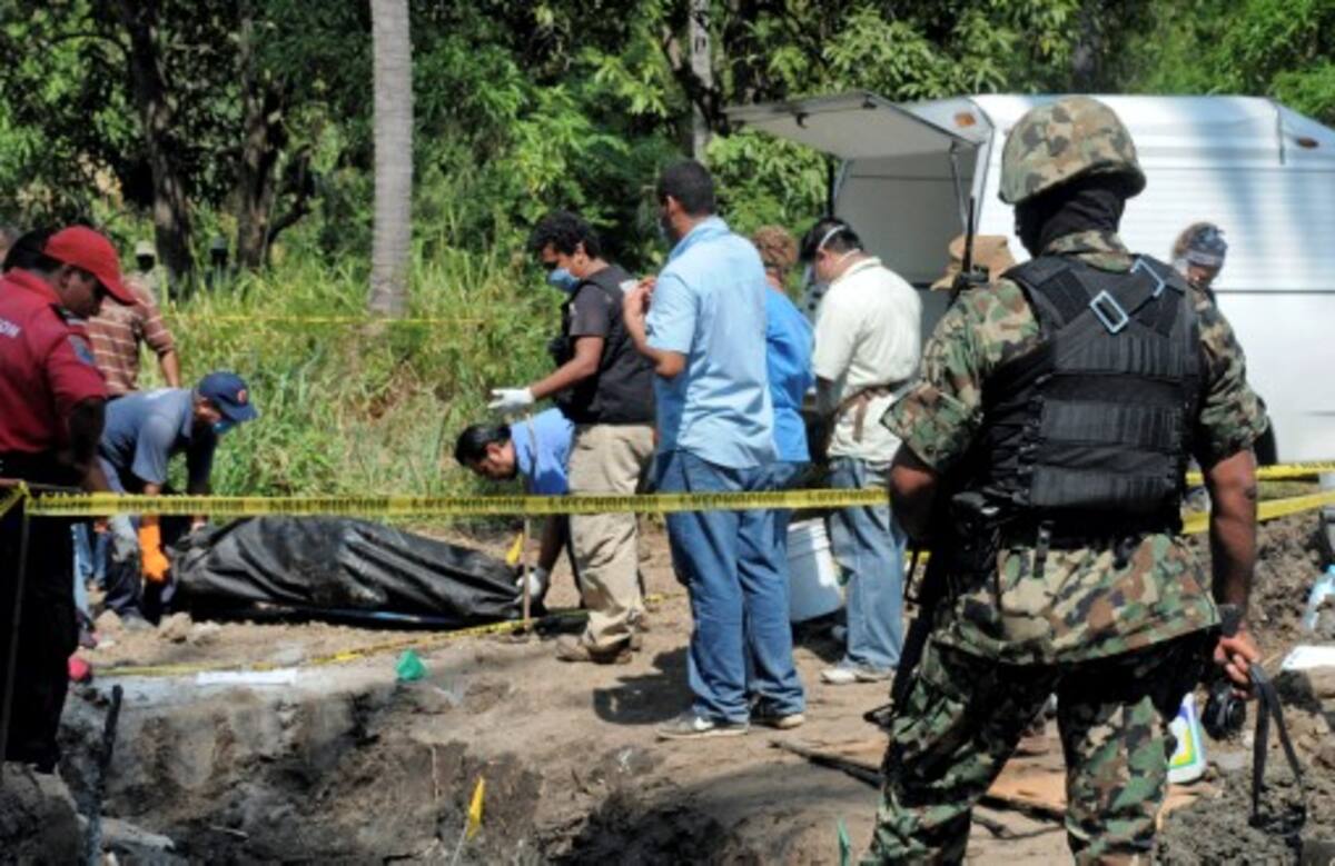 A Mexican Navy soldier watch as forensic workers remove a body which was buried at a field in the town of Tuncingo, southern Mexico, Wednesday Nov. 3, 2010. Authorities recovered at least nine bodies digging into an area mentioned in a video posted in YouTube as the burial site of 20 people of Michoacan state who were kidnapped last Sept. 30. (AP Photo/Bernandino Hernandez) marines guard the perimeter as civil protection and forensic workers dig for bodies at a clandestine that was found in the town of Tuncingo, Mexico Wednesday Nov. 3, 2010. Mexican police have recovered at least nine bodies in a mass grave identified in a narco-video as the burial site for 20 men kidnapped in the resort city of Acapulco last Sept. 30.(AP Photo/Bernandino Hernandez)
