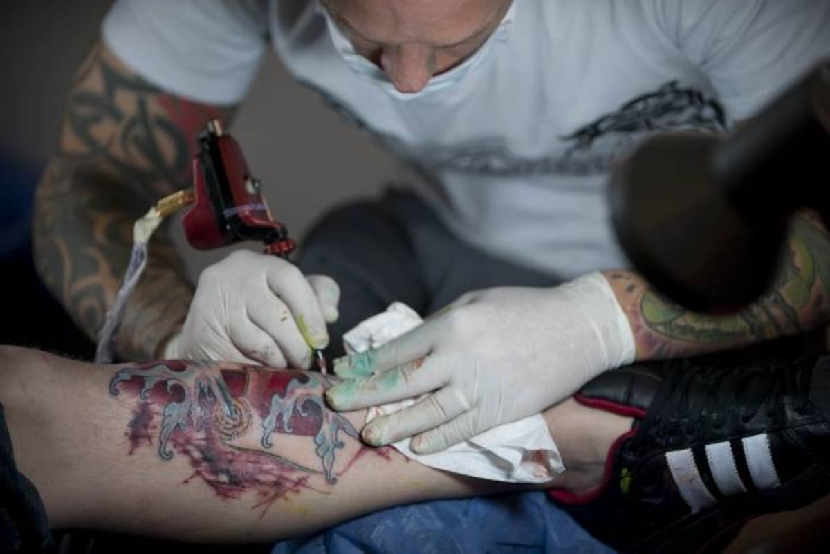 A tattoo artist works on a customer during the Fifth International Tattoo Convention in Bogota, Colombia, on June 4, 2011. AFP PHOTO/EITAN ABRAMOVICH