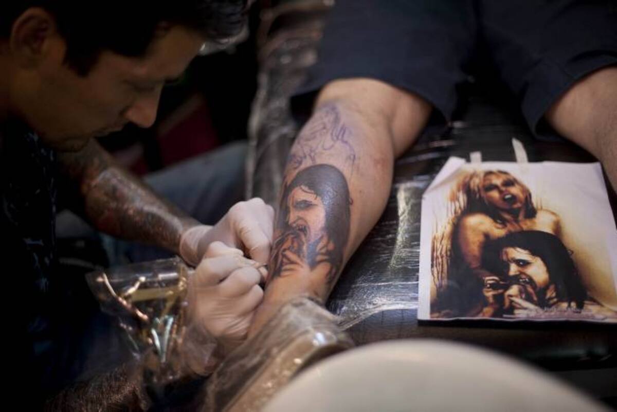 A tattoo artist works on a customer during the Fifth International Tattoo Convention in Bogota, Colombia, on June 4, 2011. AFP PHOTO/EITAN ABRAMOVICH