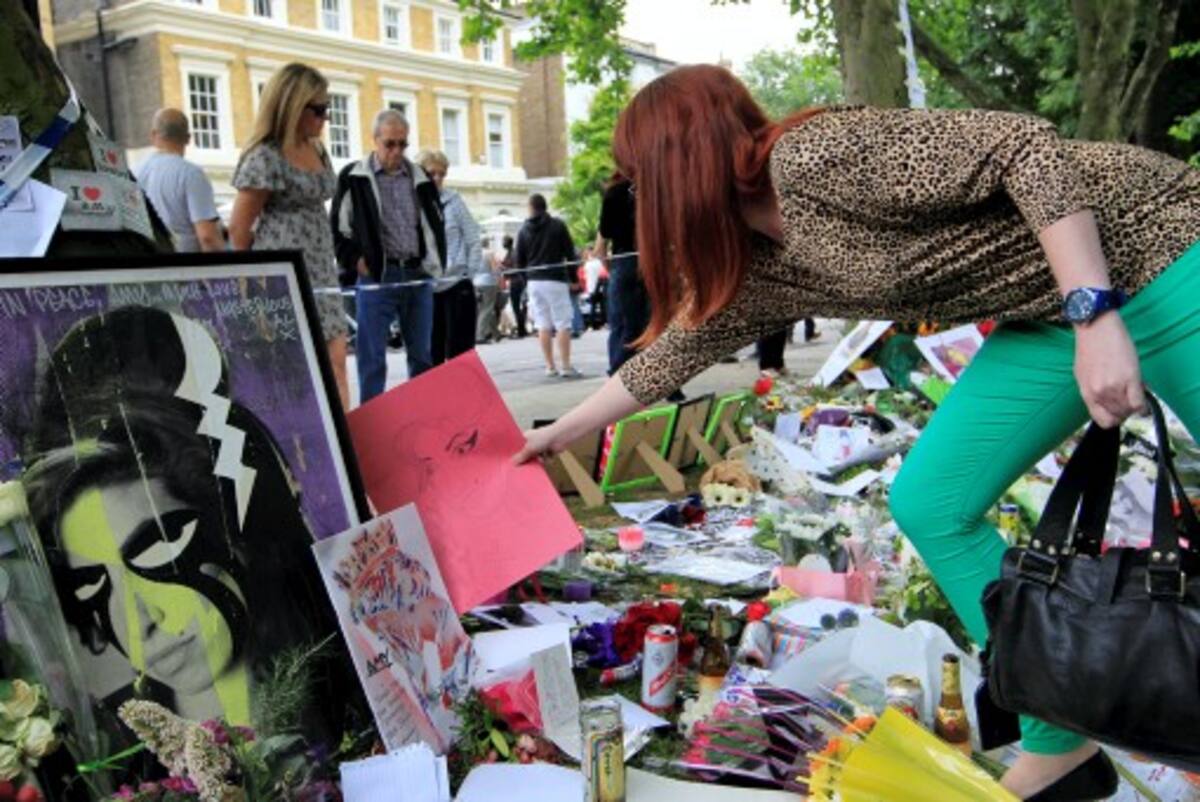 Miles de fans exparesaron su dolor dejando flores, cartas y demás recuerdos en frente del apartamento donde residía Amy Winehouse. AP Sang Tan
