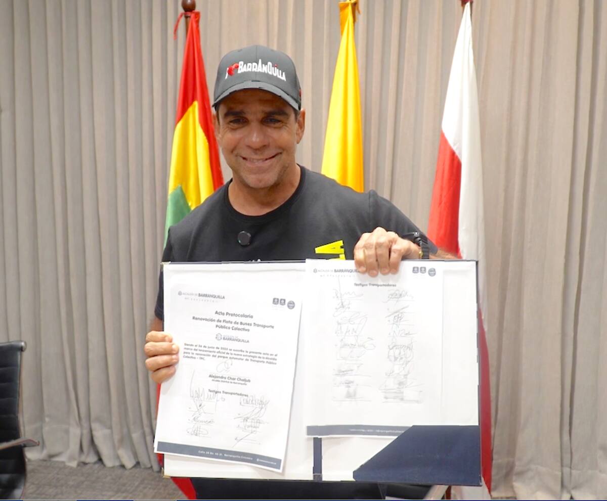 El alcalde Alejandro Char muestra el documento que firmaron los empresarios del transporte con la Alcaldia de Barranquilla.//Cortesía.