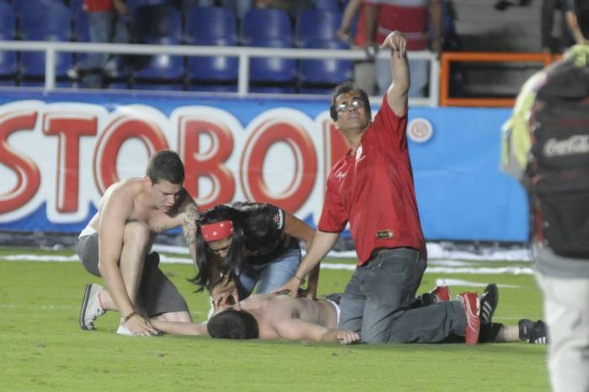 Algunos hinchas que resultaron lesionados en las graderías del escenario debieron ser atendidos en la gramilla del Estadio después del encuentro. COLPRENSA