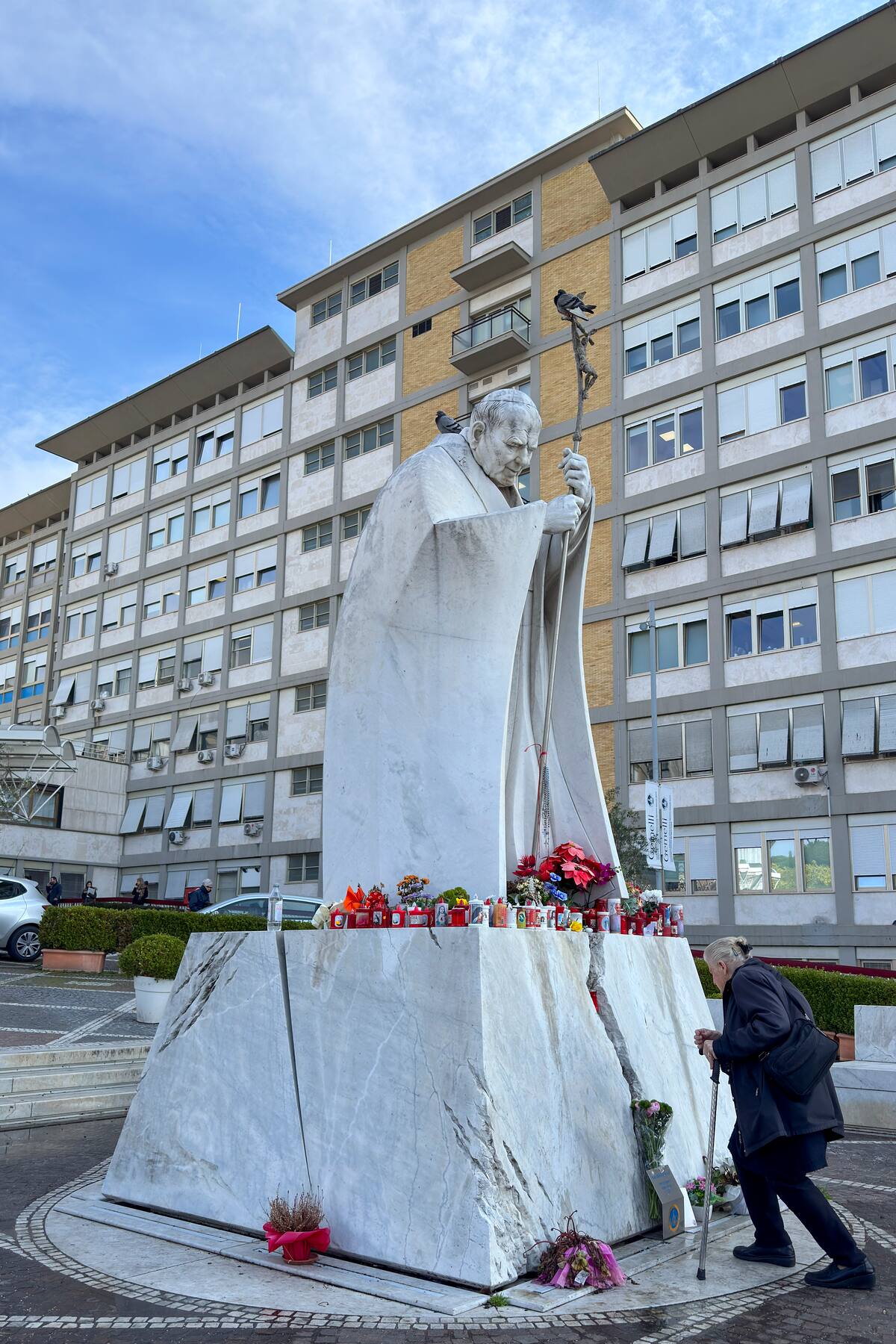 Una mujer reza ante una escultura de el papa Francisco colocada en el exterior del hospital Policlínico Gemelli de Roma. //EFE