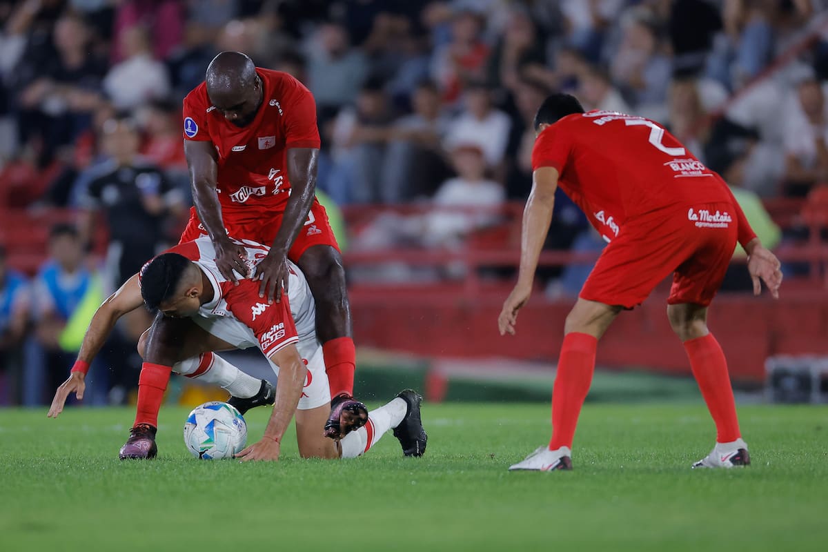 Leonardo Sequeira (abajo) de Huracán disputa el balón con Éder Álvarez Balanta de América este miércoles, en un partido de la fase de grupos de la Copa Sudamericana entre Huracán y América de Cali. //EFE