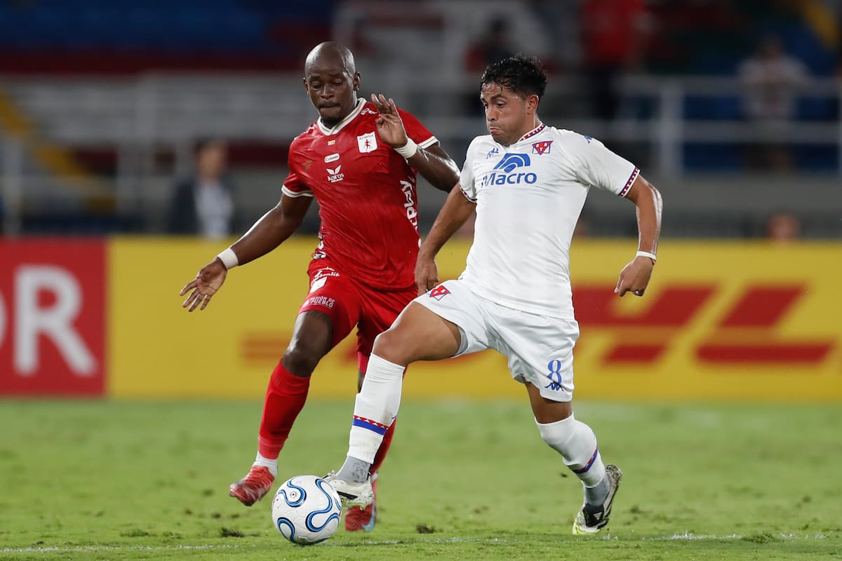Tilman Palacios (i), de América, disputa el balón con Martín Garay, de Tigre, en un partido de la fase de grupos de la Copa Sudamericana. //Foto, EFE: Ernesto Guzmán