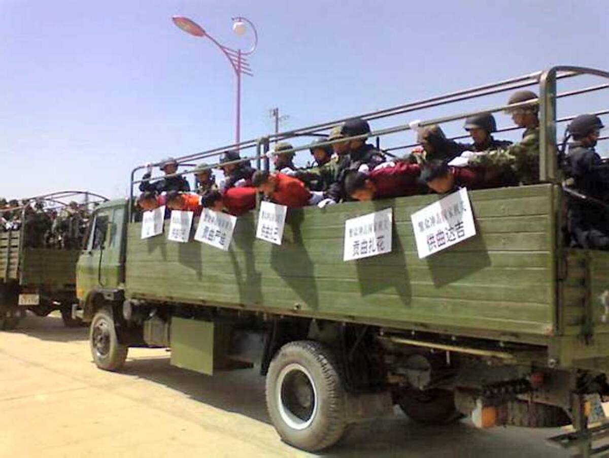 Los monjes con la cabeza baja y la pancarta al cuello. AFP FreeTibet
