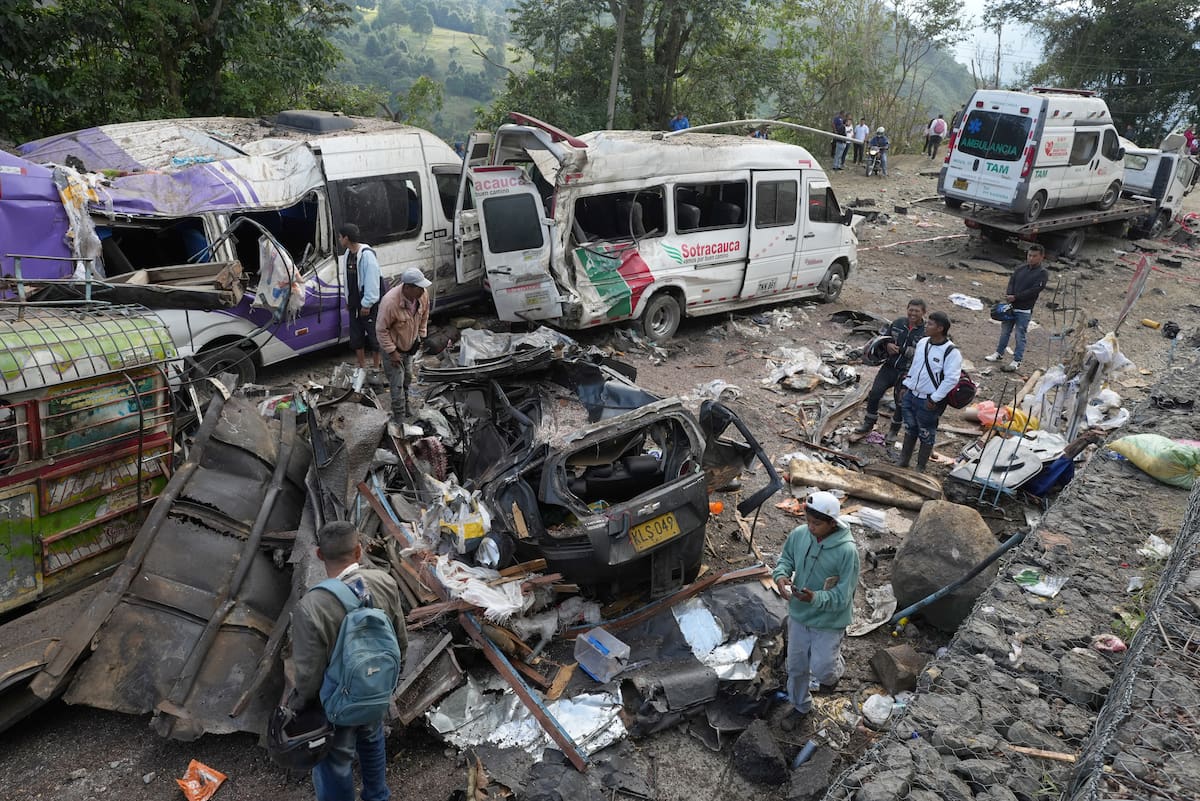 Personas observan este domingo vehículos destruidos por un atentado ocurrido en la Vía Panamericana en Cajibío (Colombia). // Foto: EFE
