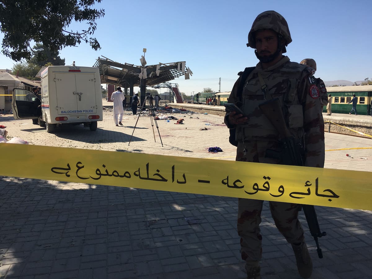 Agentes de seguridad paquistaníes inspeccionan el lugar de una explosión en una estación de tren en Quetta. //EFE