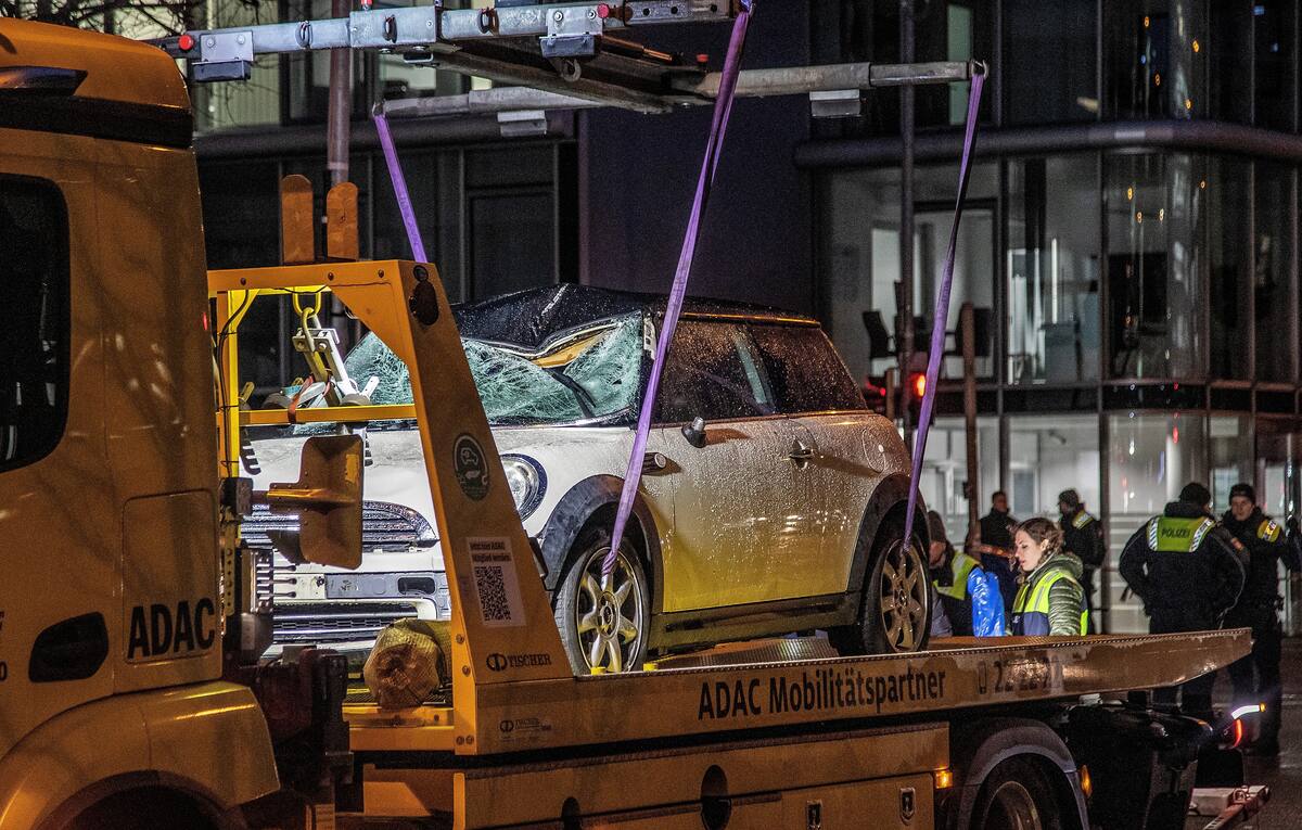 Un coche dañado es levantado con una grúa en el lugar donde un vehículo embistió una manifestación de Ver.di en Múnich, Alemania. //EFE