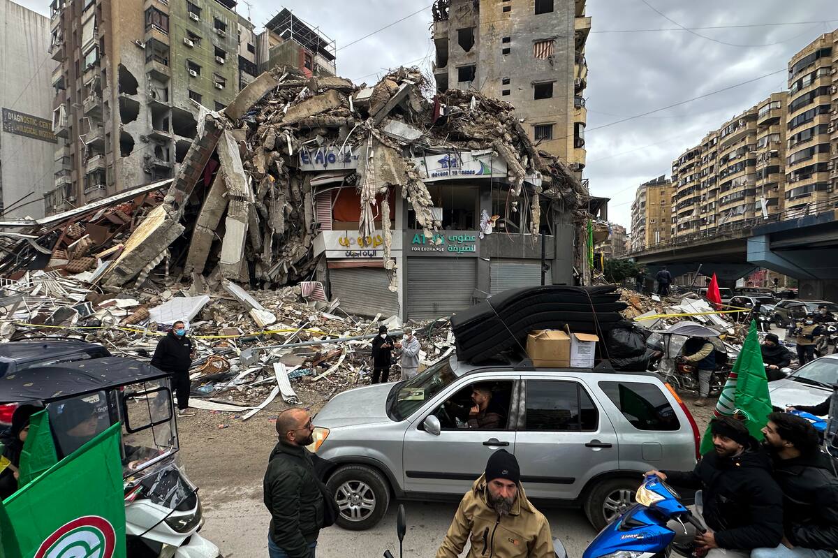 Un grupo de personas conduce un automóvil con pertenencias frente a un edificio dañado, mientras los desplazados internos se preparan para regresar a sus hogares después de un alto el fuego con Israel. //EFE