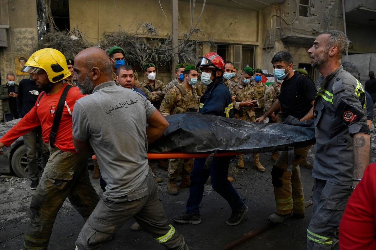 Los equipos de rescate llevan un cuerpo en una camilla después de que los ataques aéreos israelíes alcanzaran una zona residencial en el barrio de Basta, en el centro de Beirut, Líbano. //EFE