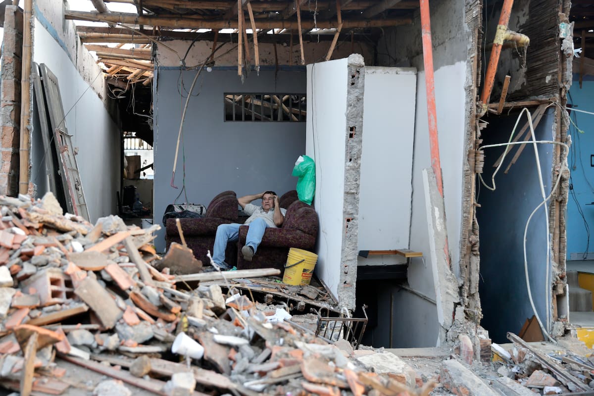 Una persona espera junto a los escombros de una vivienda este martes, en el sector de Corocito en Pereira (Colombia). EFE/ Carlos Ortega