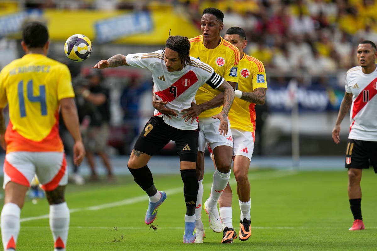 Paolo Guerrero (9) de Perú y Yerry Mina, atrás, de Colombia, compiten por el balón durante un partido de clasificación para la Copa del Mundo 2026 en el estadio Metropolitano de Barranquilla. //AP: Fernando Vergara