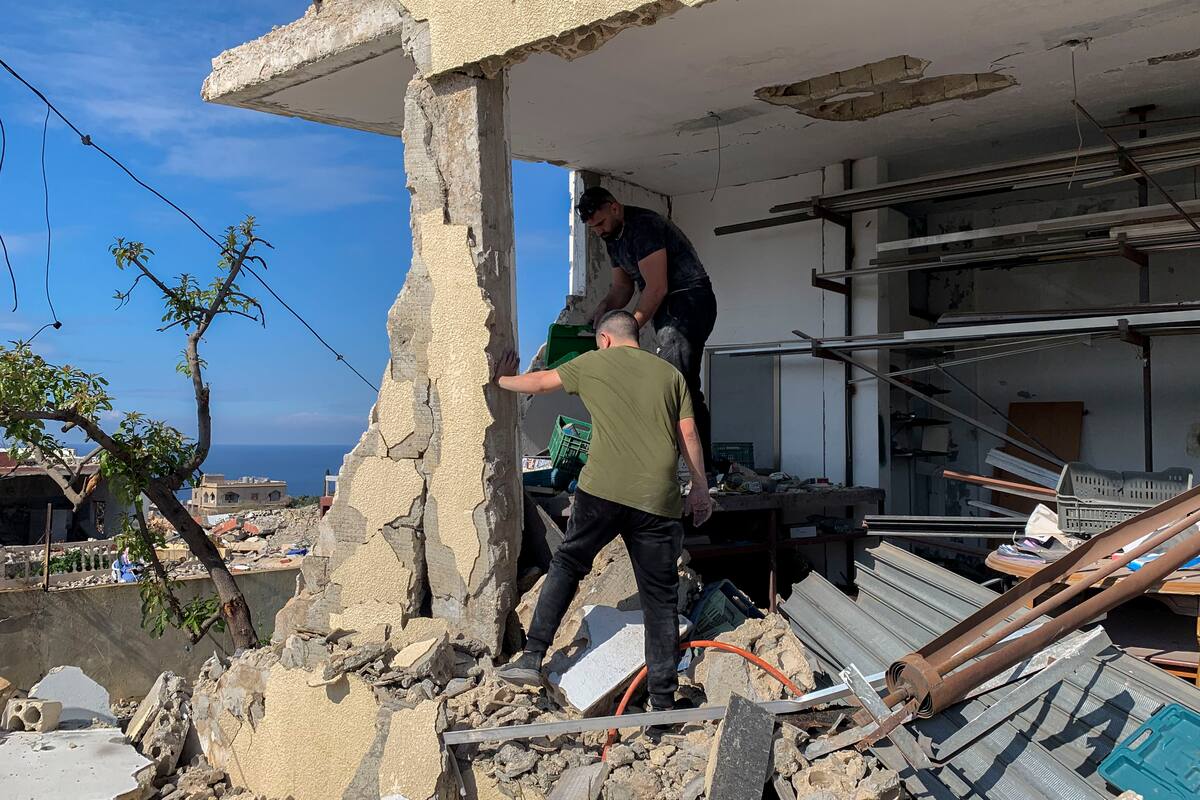 Dos hombres buscan enseres que puedan rescatar de entre las ruinas de su vivienda en Naqoura (Líbano) este domingo, una localidad libanesa a apenas 3 kilómetros de la frontera con Israel adonde los residentes pudieron entrar por primera vez esta semana, después de que las tropas israelíes se retiraran al calor del recién expirado alto el fuego. EFE/ Noemí Jabois