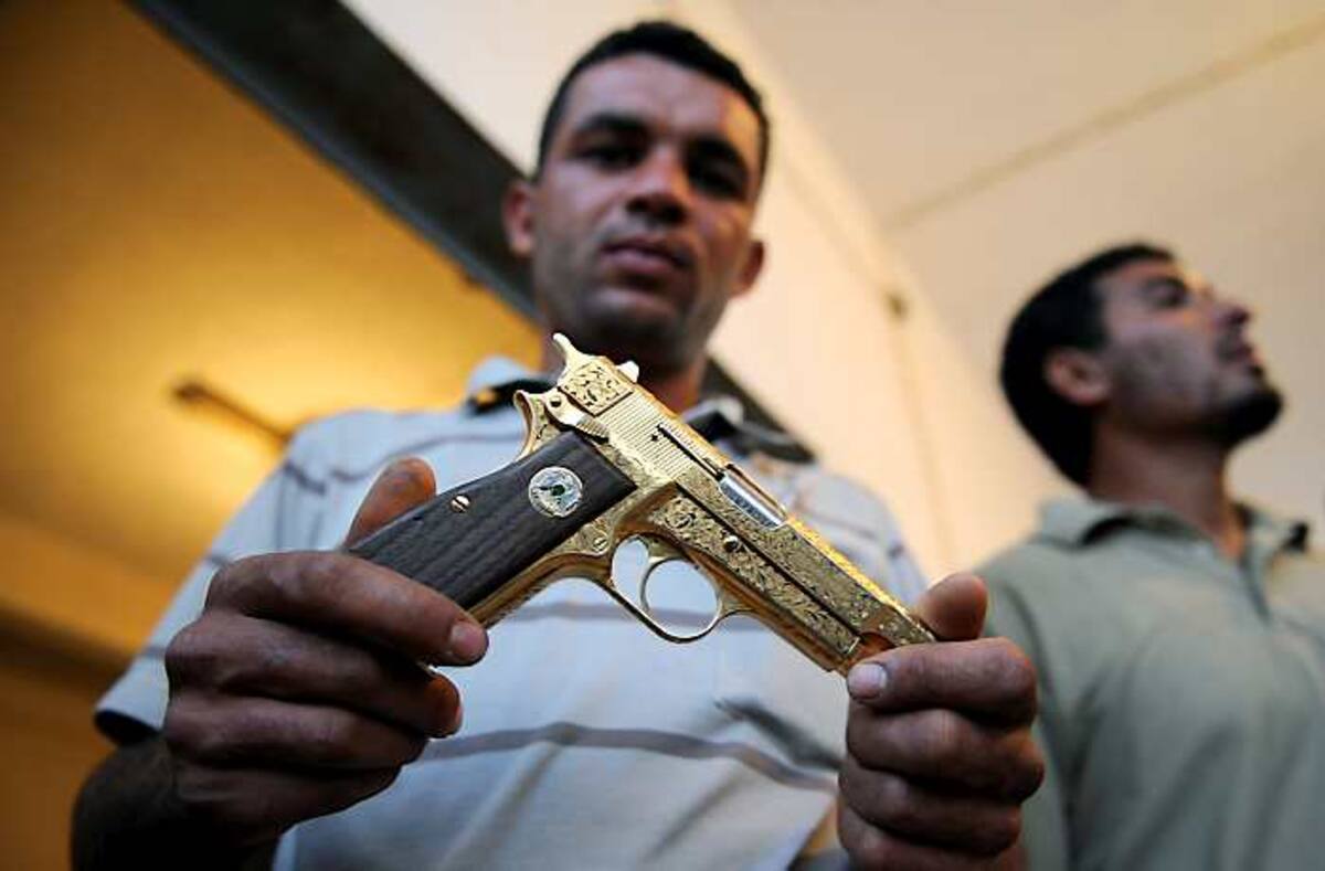 La pistola de oro de Gadafi es tomada como un trofeo por los rebeldes. AFP