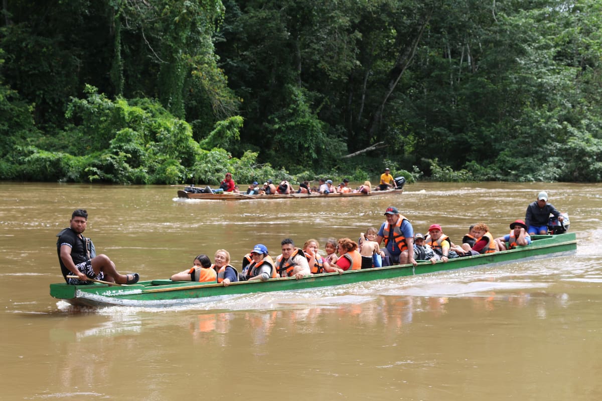 Migrantes llegan en canoa por el río Tuquesa desde el poblado de Bajo Chiquito hasta el centro de recepción de Lajas Blancas en el Darién, la frontera natural que comparten Panamá y Colombia. // Foto: EFE