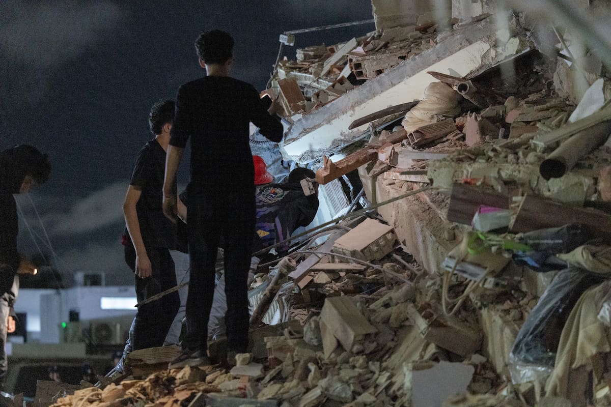 Personas buscan entre los escombros este miércoles, luego de dos fuertes terremotos que sacudieron el Caribe venezolano, en Caracas (Venezuela). El principal fue un sismo de magnitud 7,5, informó el sistema oficial de alerta de tsunamis de Estados Unidos. EFE/ Rayner Peña