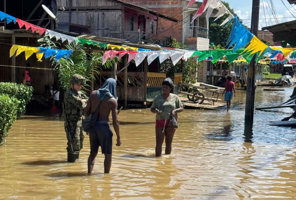Solado con dos personas en una calle inundada, tras inundaciones en Alto Baudó. // Foto: EFE