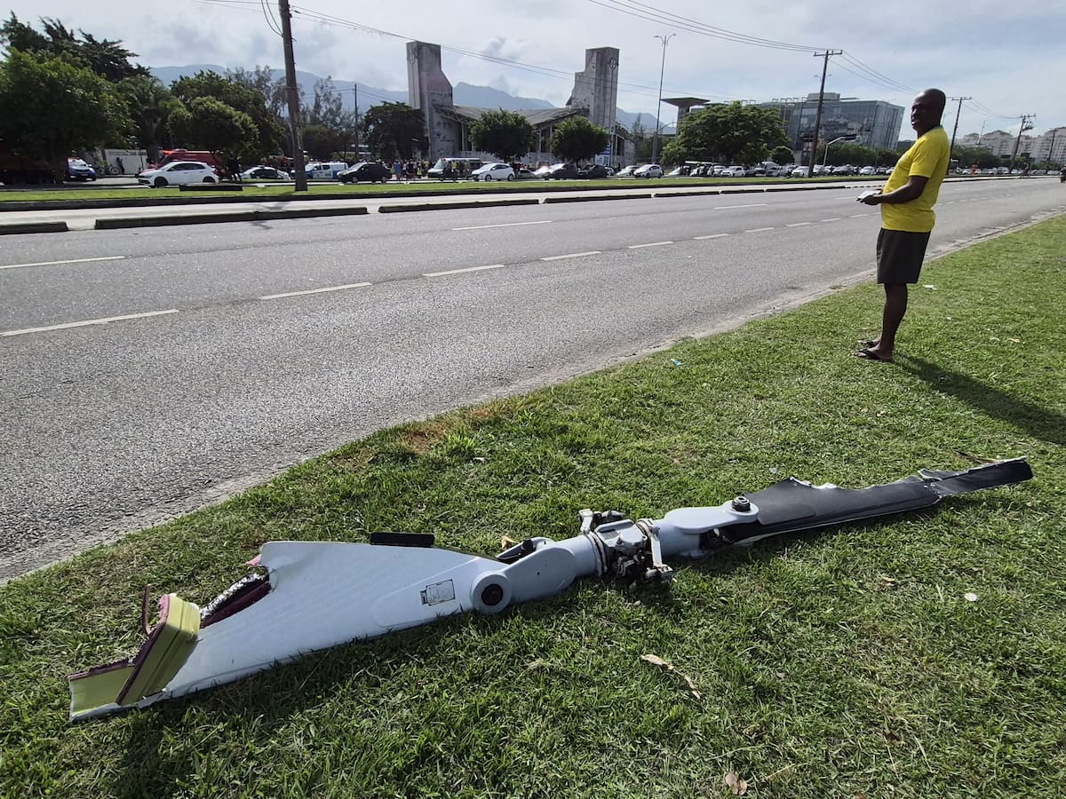 Fotografía cedida este 14 de junio por Roberta Durço que captó a una persona al observar un fragmento de uno de los dos helicópteros que colisionaron este domingo en el aire, en el barrio Recreio dos Bandeirantes, en Río de Janeiro (Brasil). // Foto: EFE - Roberta Durço.