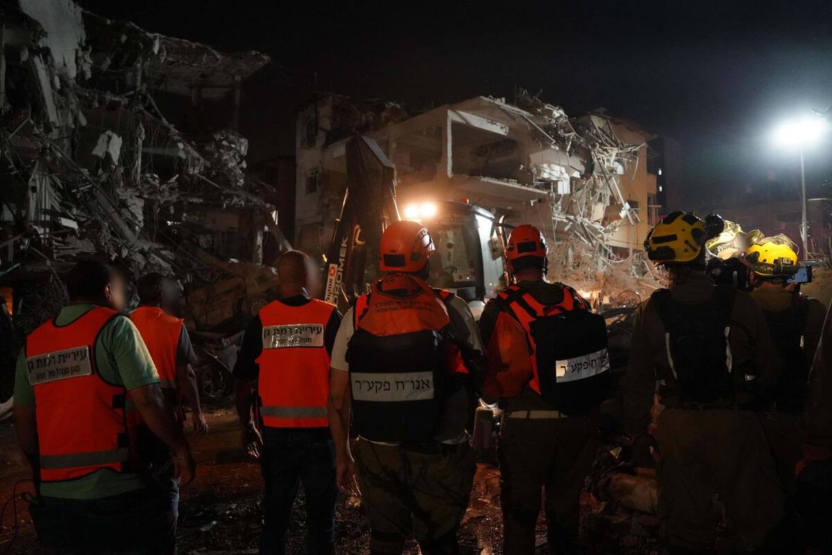 Fotografía cedida por las Fuerzas de Defensa de Israel (FDI) donde se observa a integrantes de los cuerpos de emergencia junto a un edificio destruido por un misil iraní este sábado, en Tel Aviv (Israel). EFE/ Fuerzas de Defensa de Israel