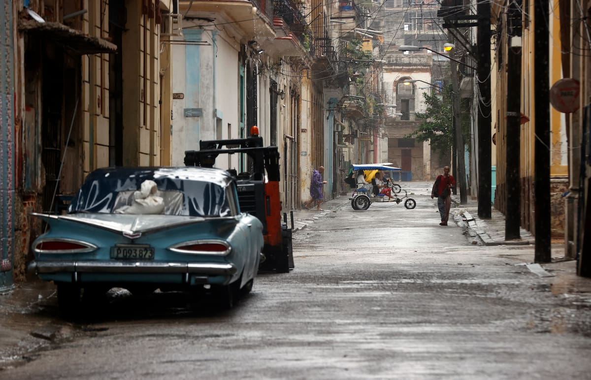 Personas caminan por una calle durante las fuertes lluvias debido al paso del huracán Rafael en La Habana (Cuba). //EFE