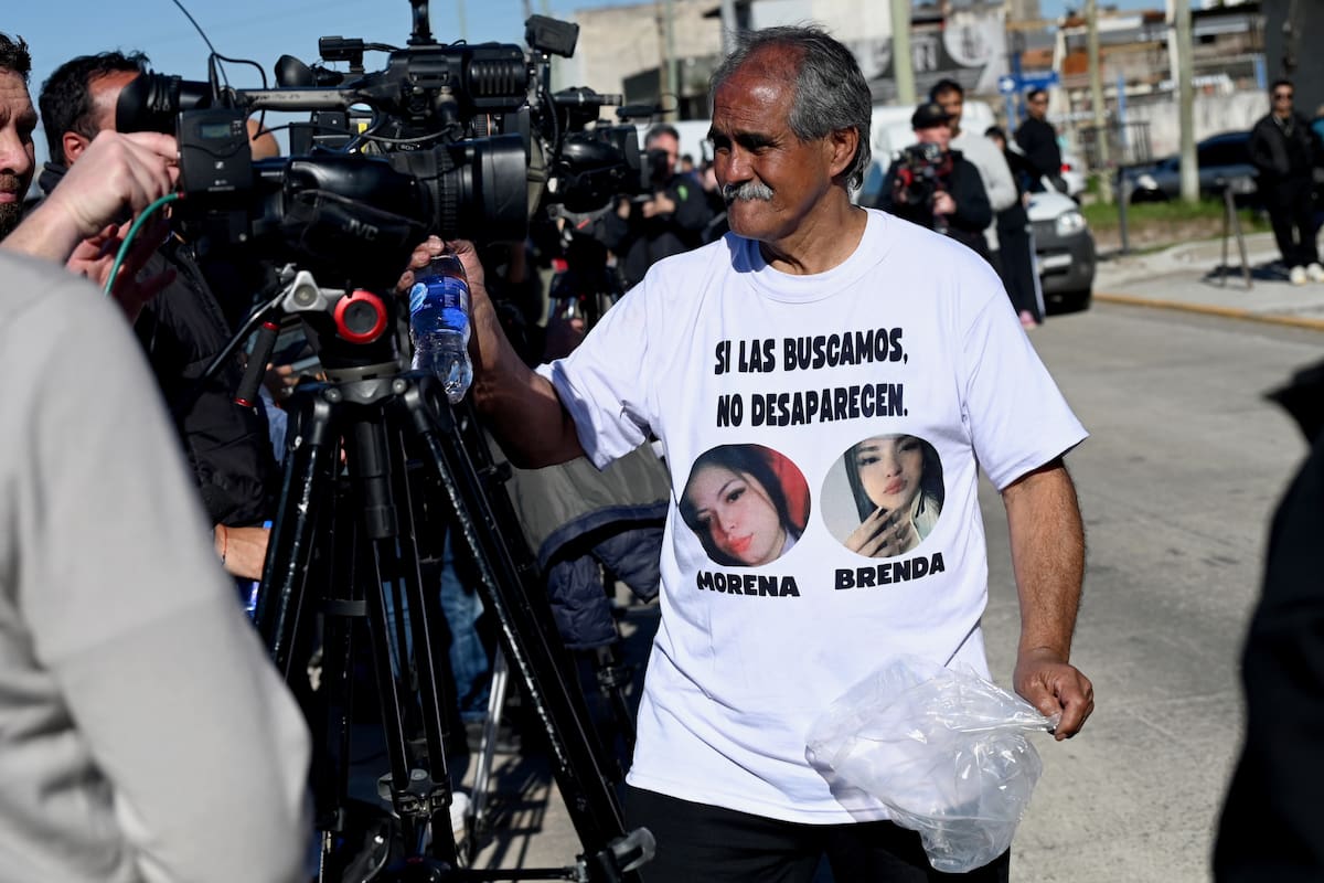 Una persona reparte agua a los periodistas, afuera del velatorio de las jóvenes asesinadas Brenda del Castillo y Morena Verdi este jueves, en el barrio San Justo, en Buenos Aires (Argentina).