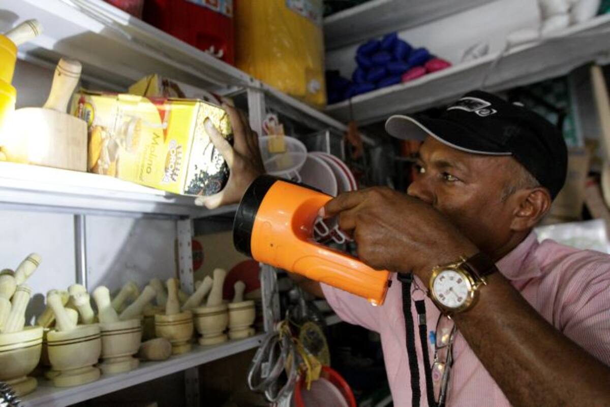 Los comerciantes de Bazurto deben usar lámparas de mano y velas para atender su negocio. Archivo.