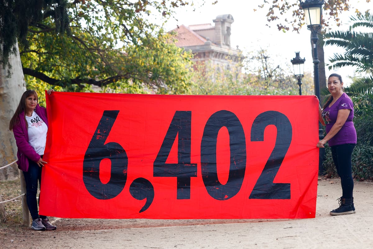 Mujeres sostienen un cartel con la cifra de 6.402 víctimas de los llamados 'falsos positivos'. // Foto: EFE/Quique García