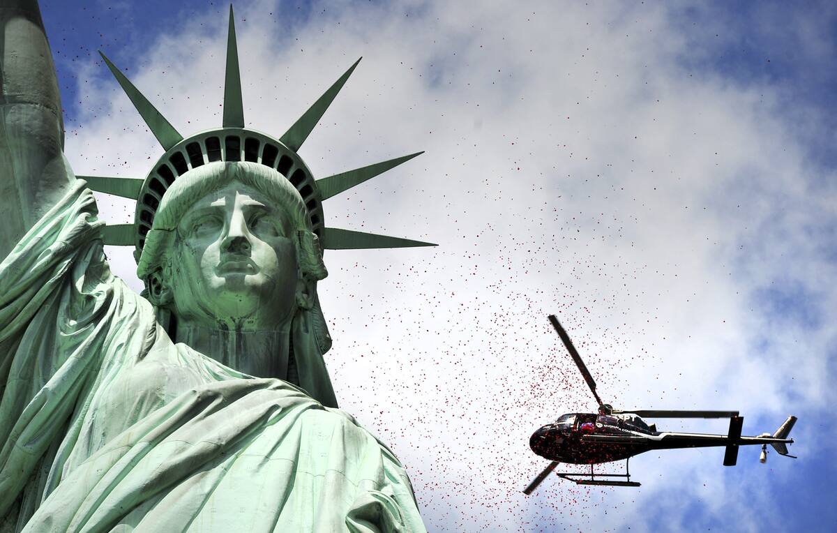 Fotografía de archivo en donde se ve un helicóptero que pasa junto a la Estatua de la Libertad en la ciudad de Nueva York, Estados Unidos. // EFE/Justin Lane
