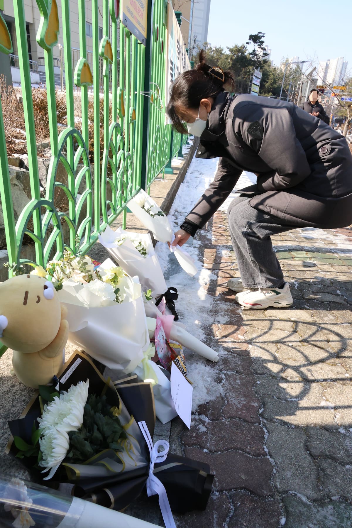 Una mujer coloca un ramo de crisantemos en una escuela primaria en la ciudad central de Daejeon, Corea del Sur. //EFE