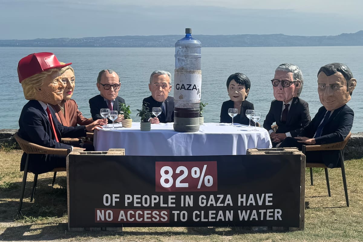 Siete activistas con máscaras que recreaban a los siete líderes del G7 se sentaron este martes a orillas del lago Lemán y brindaron con agua contaminada cerca de donde se celebra la cumbre de Évian, un acto con el que la organización Oxfam Intermón protestó por la falta de acción de los más poderosos frente a las violaciones de derechos humanos en Gaza, incluida la escasez de agua potable. //EFE/ Antonio Broto.