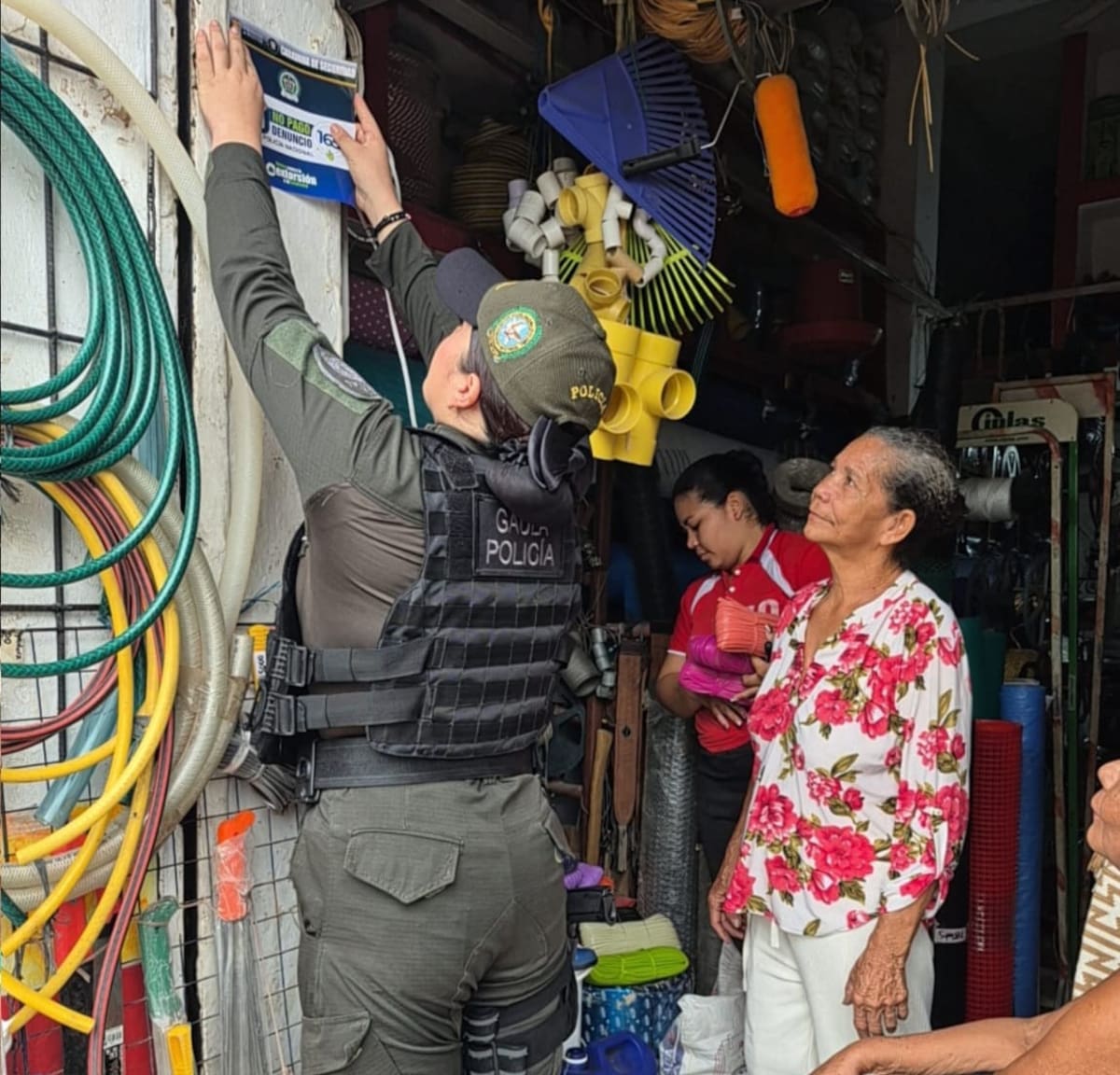 Integrantes del Gaula pegan afiches informativos durante jornada contra la extorsión en Magangué. // FOOT: POLICÍA DE BOLÍVAR.