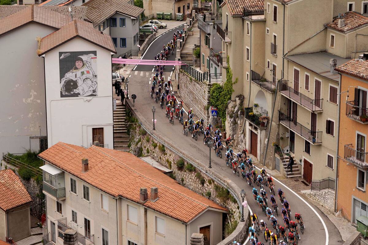 El grupo pedalea junto a un edificio que muestra un mural de la astronauta italiana Samantha Cristoforetti durante la sexta etapa del Giro de Italia de Potenza a Nápoles. //AP