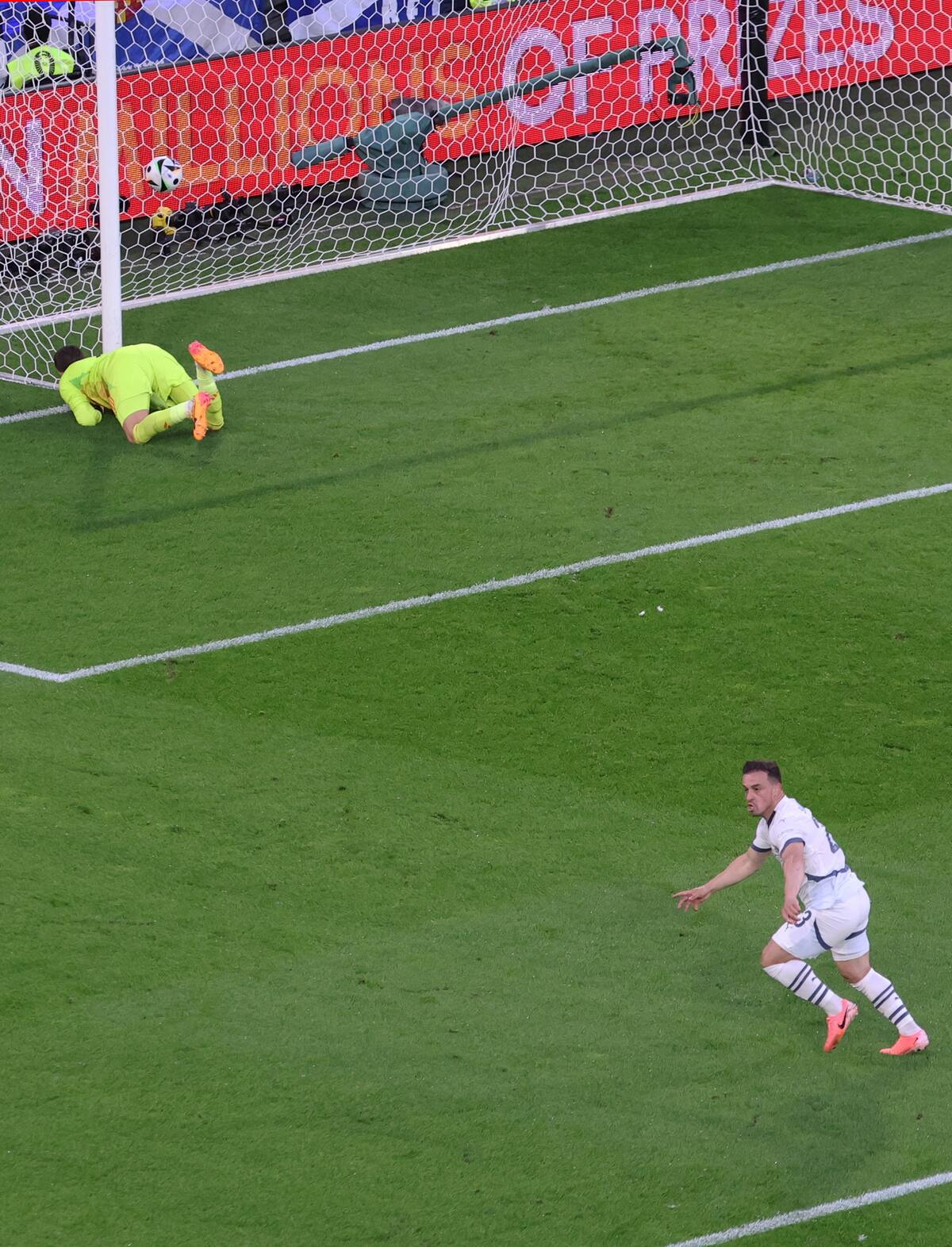 Xherdan Shaqiri (abajo) de Suiza celebra marcar el gol del empate 1-1 contra el portero escocés Angus Gunn (arriba) durante el partido de fútbol del grupo A de la UEFA EURO 2024 entre Escocia y Suiza, en Colonia, Alemania, el 19 de junio de 2024. //EFE