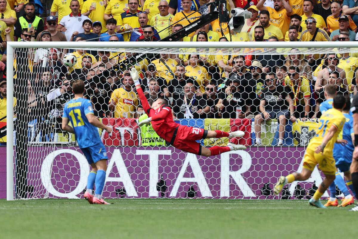 Nicolae Stanciu de Rumania (R) marca el gol 1-0 contra el portero Andriy Lunin (C) de Ucrania durante el partido de fútbol del Grupo E de la UEFA EURO 2024 entre Rumania y Ucrania, en Munich, Alemania, el 17 de junio de 2024. //EFE