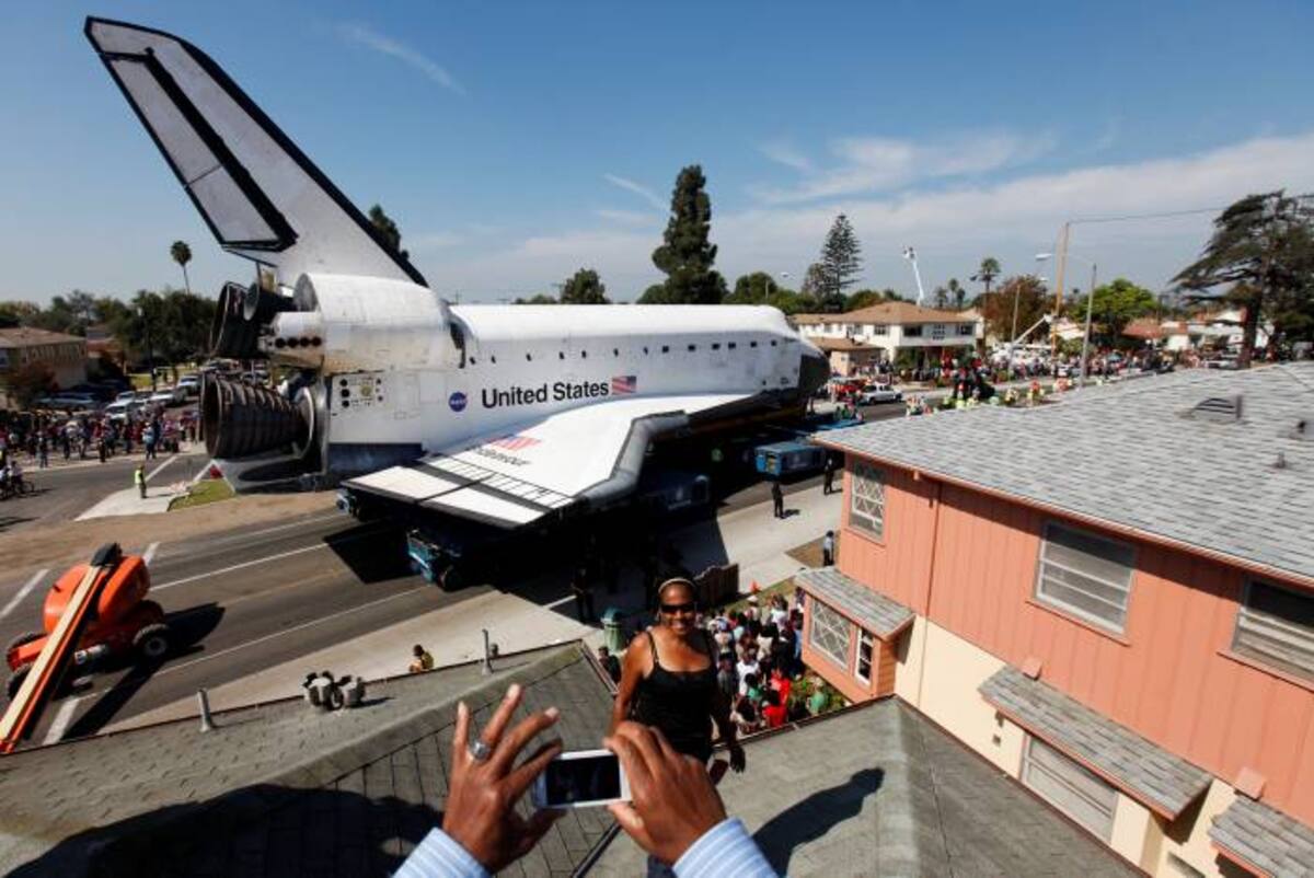 Centenares de personas, muchas con cámaras fotográficas, presenciaron el lento avance de la nave de 77,1 toneladas (170.000 libras). Su cola rebasaba en altura a los semáforos y sus alas abarcaban lo ancho de una avenida. AP Patrick T. Fallon