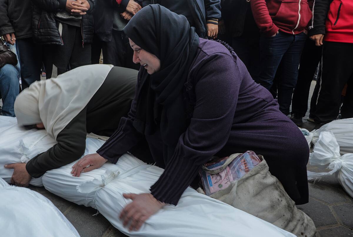 Mujeres palestinas lloran sobre los cuerpos cubiertos de los miembros de una familia palestina que fueron asesinados en un ataque aéreo israelí. //EFE