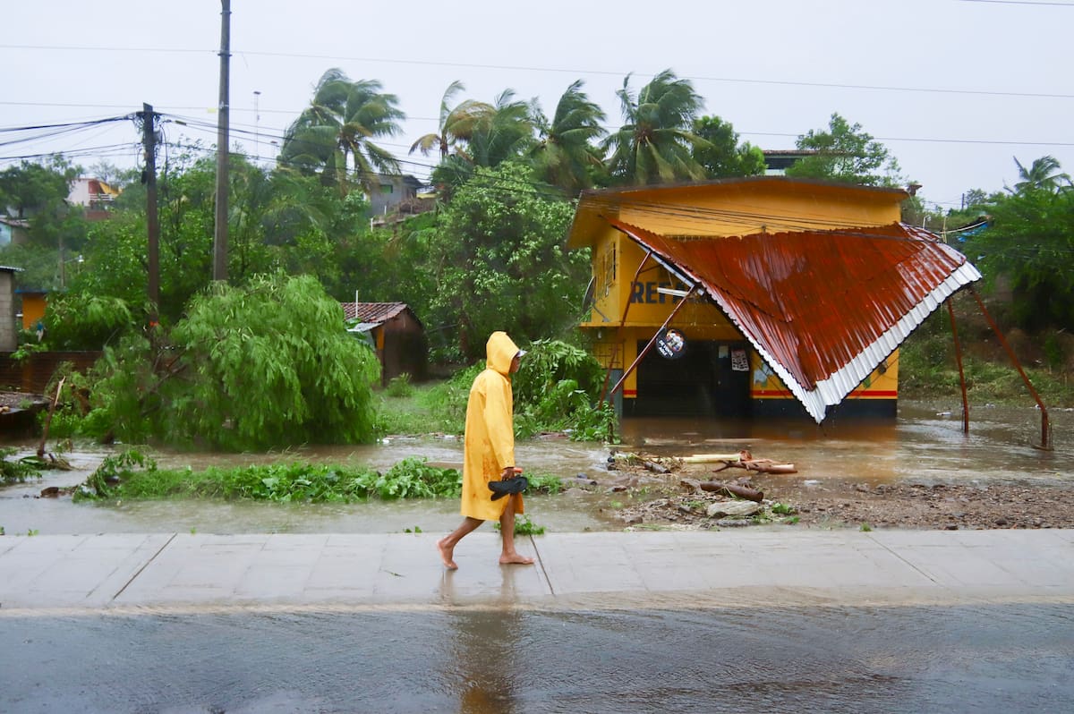 Una persona camina bajo la lluvia tras el paso del huracán John, en Marquelia, México, el 24 de septiembre de 2024. //AP