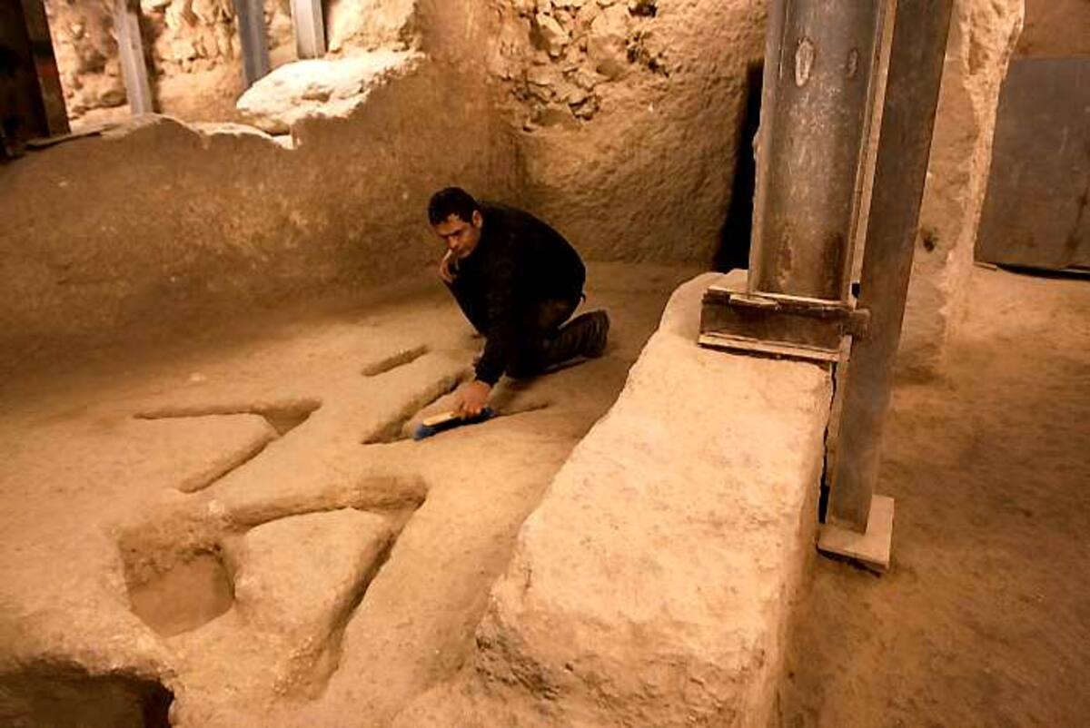 El arqueólogo Eli Shukron barre marcas talladas en las rocas en una excavación arqueológica en la Ciudad de David. AP Sebastian Scheiner