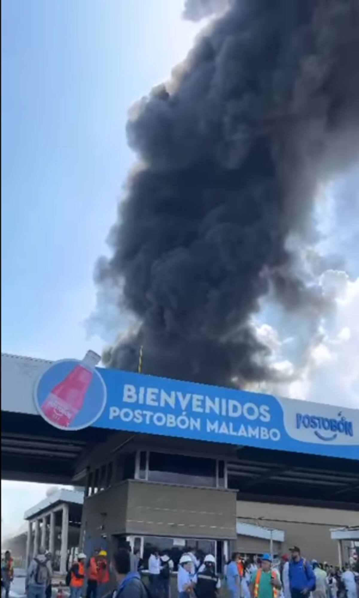 Columnas de humo negro se elevan desde la planta de Postobón en Malambo (Atlántico) mientras los bomberos controlan el incendio.