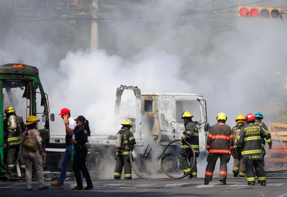 Integrantes del Cuerpo de Bomberos de Guadalajara intentan apagar un vehículo incendiado tras muerte de alias El Mencho. // Foto: EFE