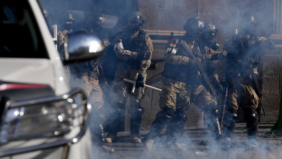 La policía militar se encuentra en medio de gases lacrimógenos que dispararon frente al palacio presidencial en la Plaza Murillo en La Paz, Bolivia. //AP Juan Karita
