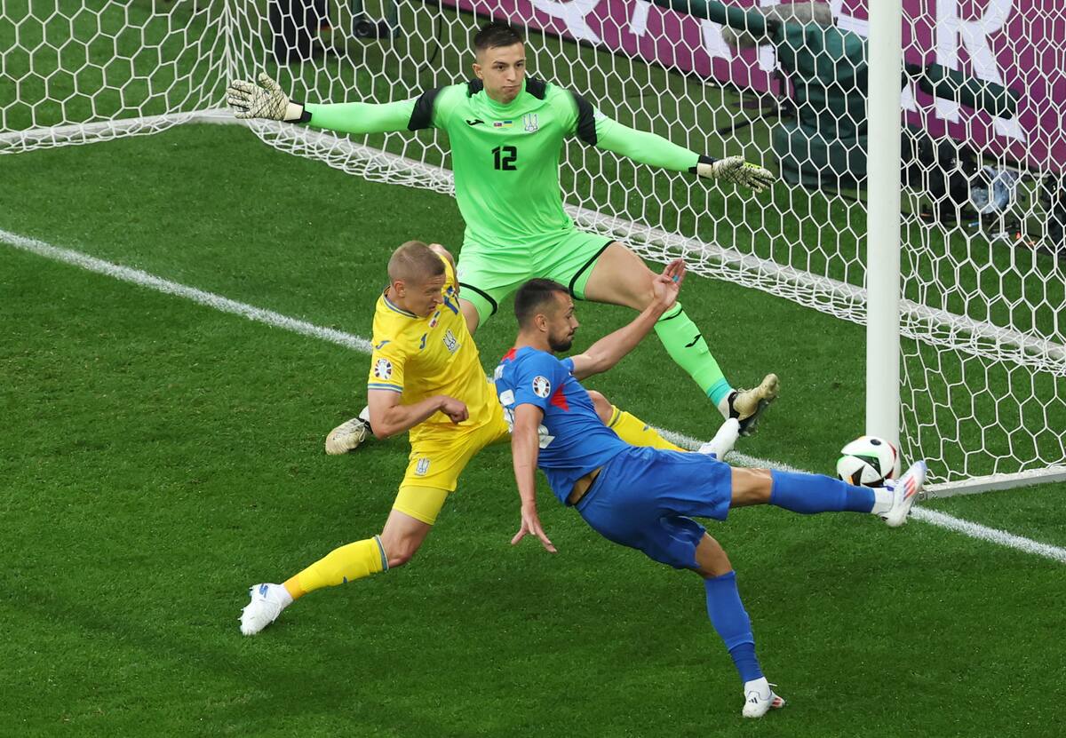 Ivan Schranz de Eslovaquia (R) intenta anotar contra el portero ucraniano Anatolii Trubin (arriba) durante el partido de fútbol del grupo E de la UEFA EURO 2024 entre Eslovaquia y Ucrania, en Dusseldorf, Alemania, el 21 de junio de 2024. //EFE
